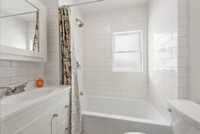 a bathroom with a bathtub a sink a window and vanity