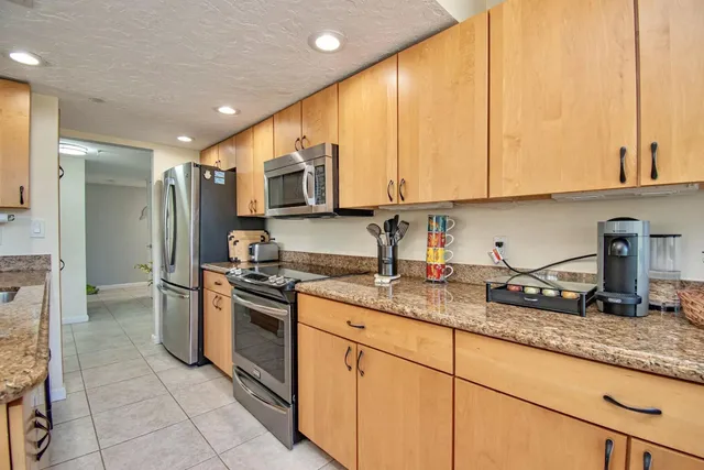 a kitchen with stainless steel appliances granite countertop a stove a sink and a refrigerator