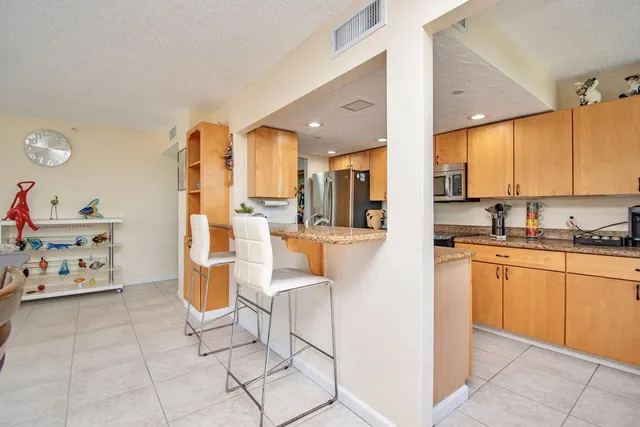 a kitchen with stainless steel appliances kitchen island granite countertop a sink and cabinets