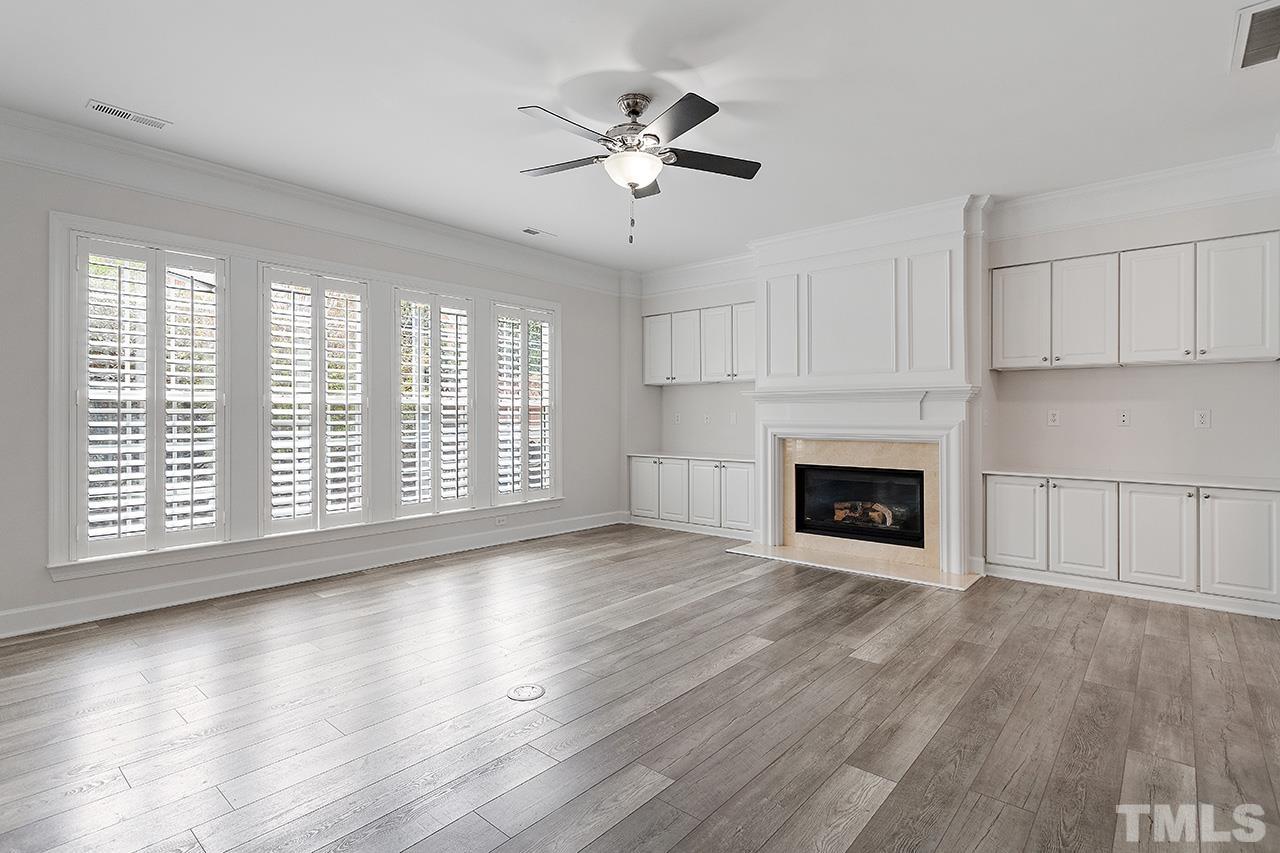 3914 Sunset Maple Court Raleigh, NC 27612 - Photo 4 of 30 a view of an empty room with wooden floor and a fireplace