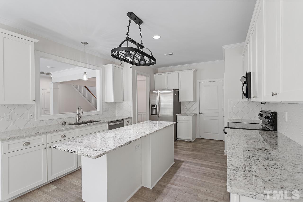 3914 Sunset Maple Court Raleigh, NC 27612 - Photo 9 of 30 a kitchen with stainless steel appliances a sink stove and refrigerator
