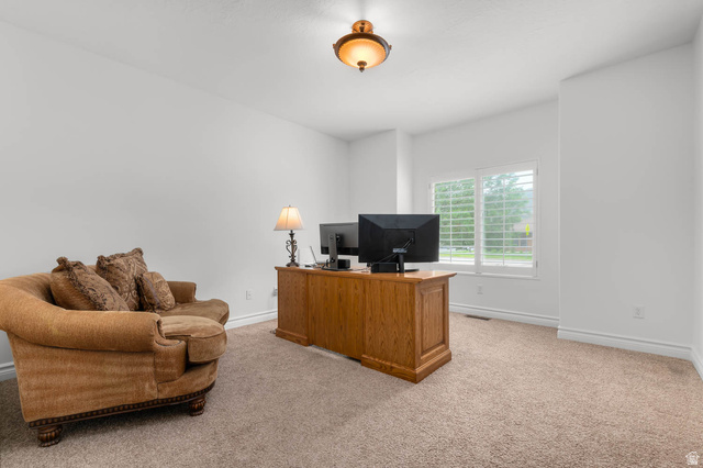 439 East 13540 South Draper, UT 84020 - Photo 4 of 46 Bright room featuring ample natural light from a window with plantation shutters, neutral-toned carpet, white painted walls, and a decorative ceiling fixture