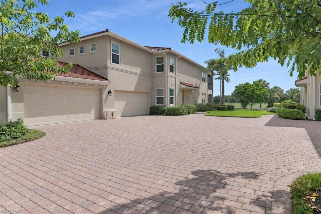 1286 Rialto Way, Unit 9202 Naples, FL 34114 - Photo 3 of 49 Mediterranean / spanish-style house featuring stucco siding, decorative driveway, and a garage.