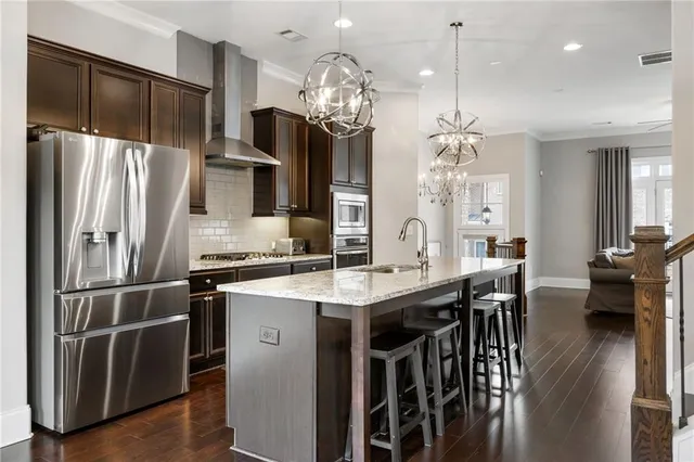 a kitchen with kitchen island granite countertop a table chairs stainless steel appliances and cabinets