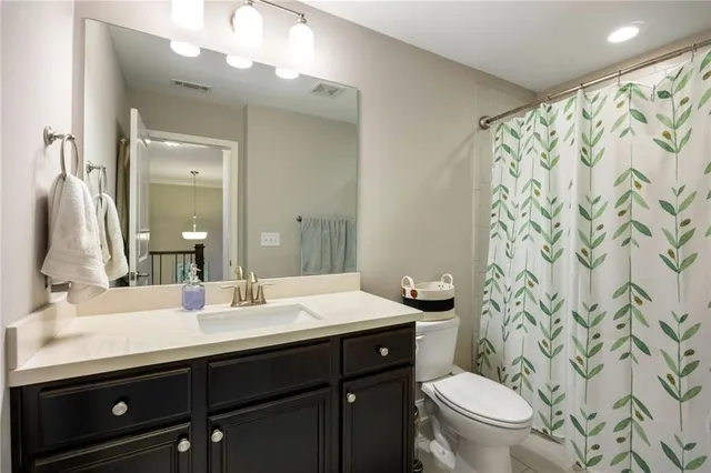 a bathroom with a double vanity sink toilet and a mirror