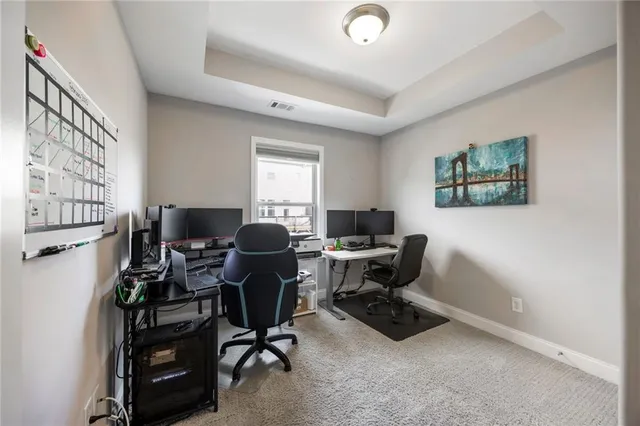 a view of a workspace with furniture and a window