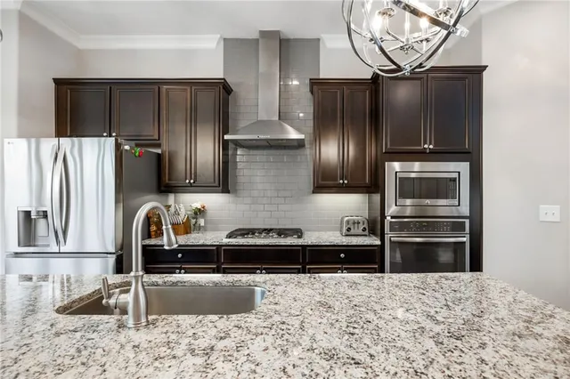 a kitchen with stainless steel appliances granite countertop a refrigerator and a sink