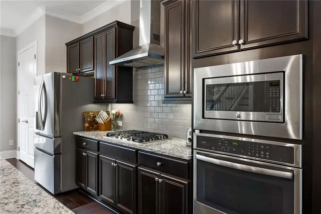 a kitchen with stainless steel appliances and granite countertop wooden cabinets