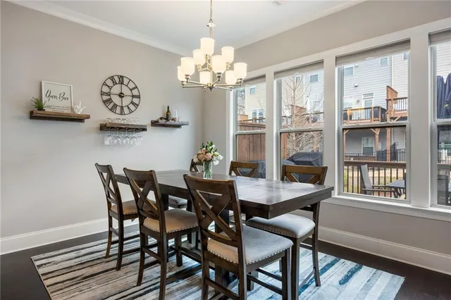 a view of a dining room with furniture a chandelier and wooden floor