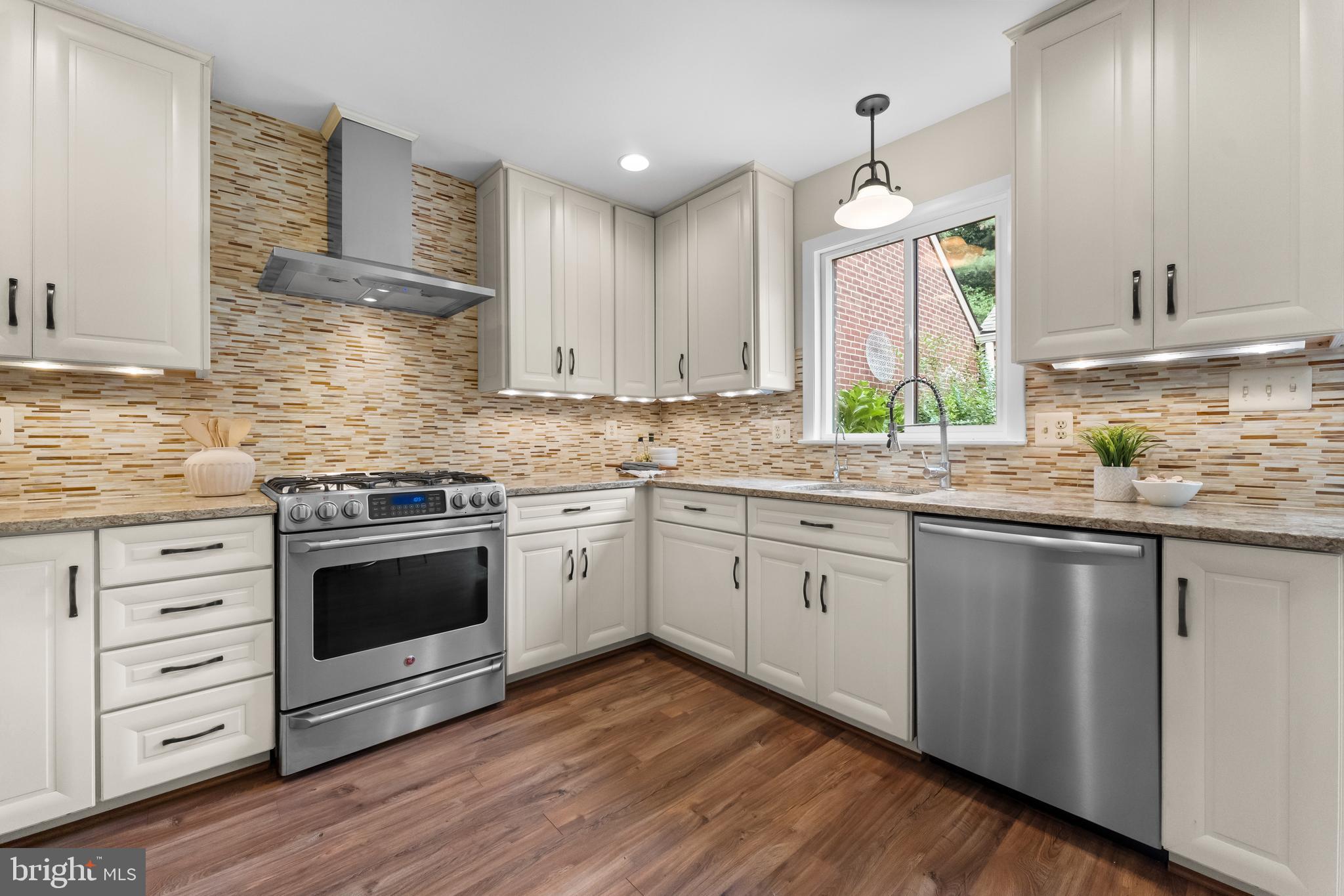 11303 Harborside Cluster Reston, VA 20191 - Photo 14 of 30 a kitchen with granite countertop cabinets stainless steel appliances a sink and wooden floor