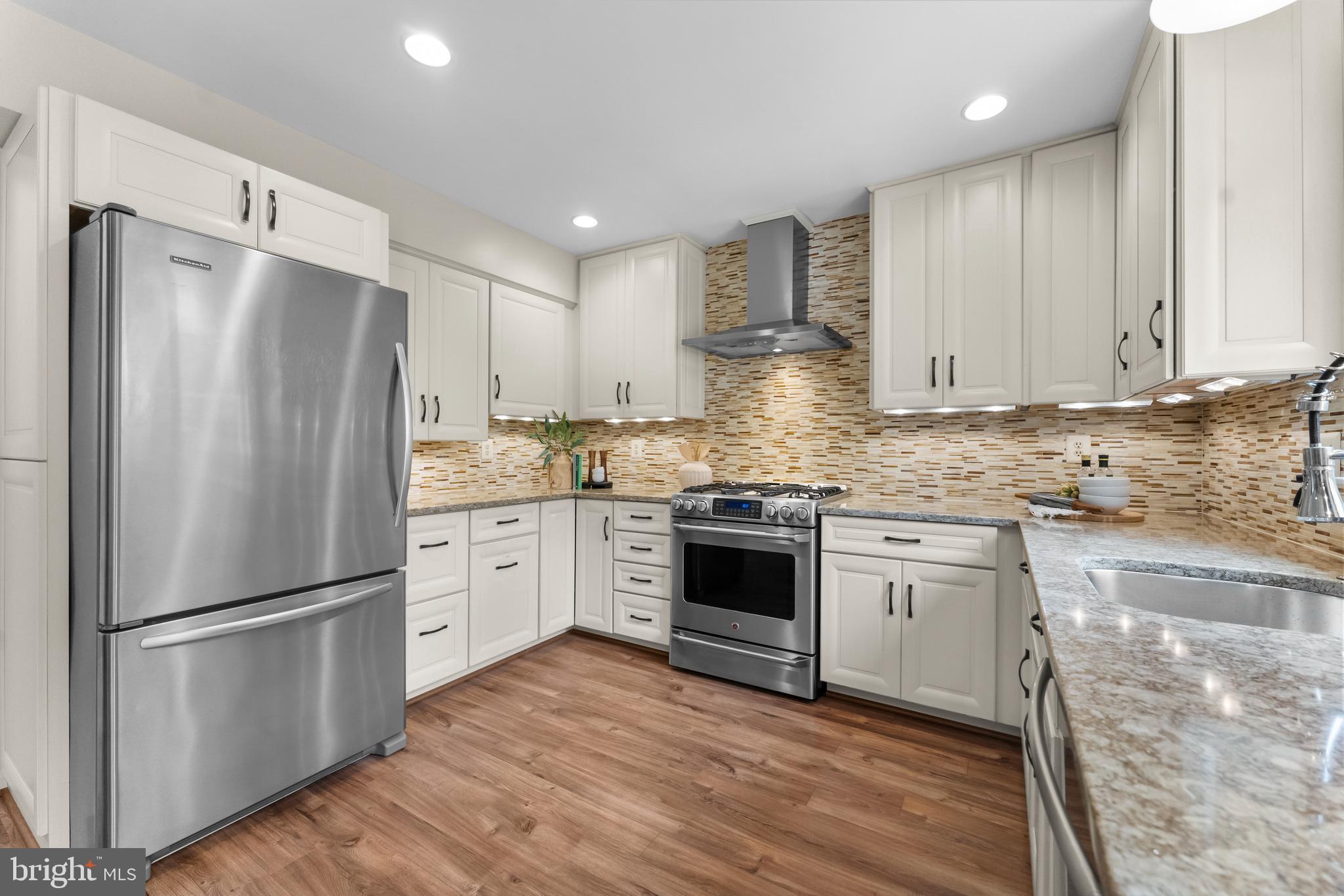 11303 Harborside Cluster Reston, VA 20191 - Photo 15 of 30 a kitchen with granite countertop white cabinets and stainless steel appliances