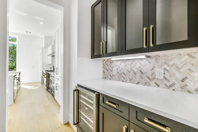 a view of kitchen with kitchen island stainless steel appliances sink refrigerator dining table and chairs