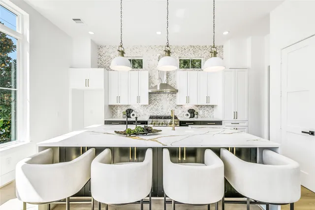 a large kitchen with kitchen island a large island in the center and stainless steel appliances