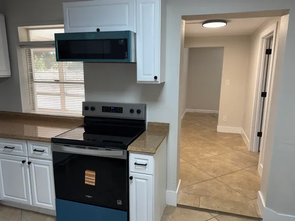 a kitchen with a refrigerator sink and cabinets