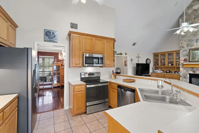 a kitchen with stainless steel appliances granite countertop a sink dishwasher stove top oven and cabinets