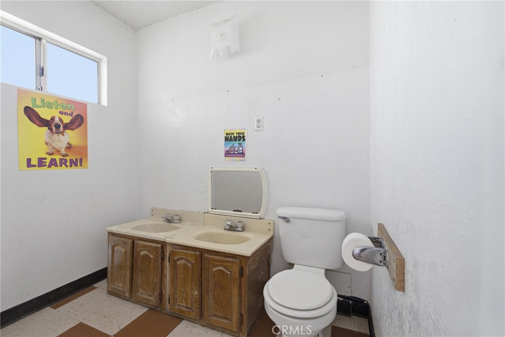 15637 Tuscola Road Apple Valley, CA 92307 - Photo 28 of 57 a bathroom with a sink a toilet and a shower curtain