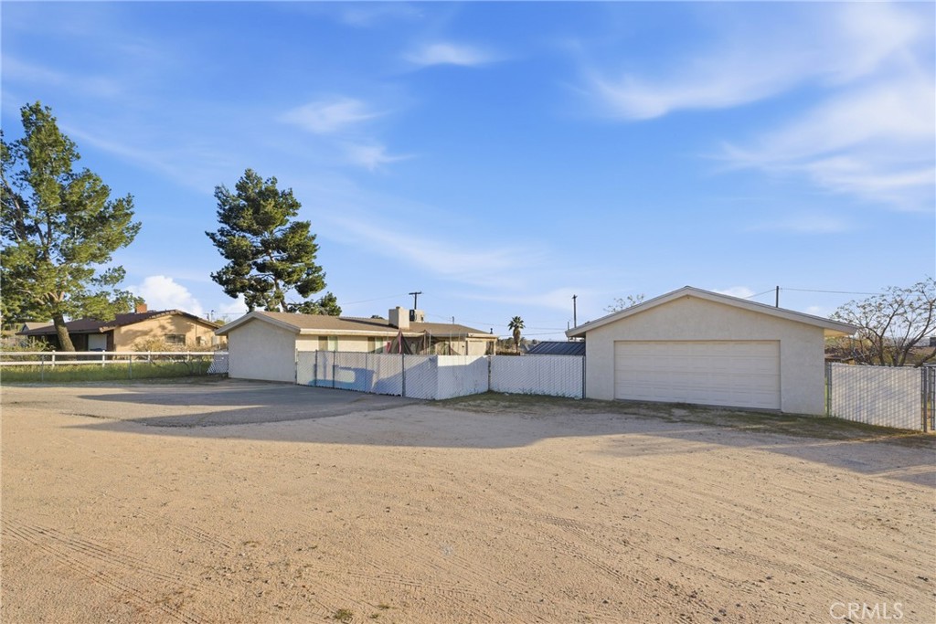 15637 Tuscola Road Apple Valley, CA 92307 - Photo 43 of 57 a view of a house with a large trees and a big yard