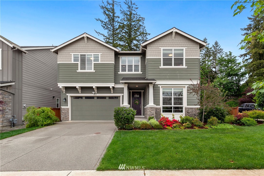 a front view of a house with a yard and trees