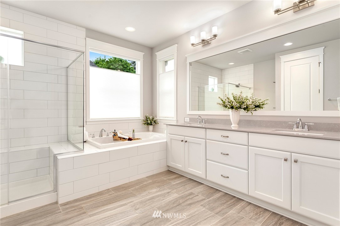 253 Field Place Southeast Renton, WA 98059 - Photo 29 of 40 a bathroom with a double vanity sink a mirror and a bathtub