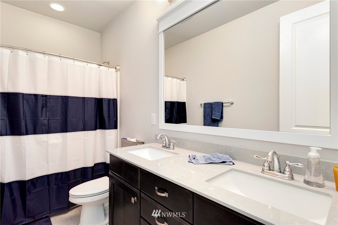 253 Field Place Southeast Renton, WA 98059 - Photo 32 of 40 a bathroom with a sink a toilet and a large mirror