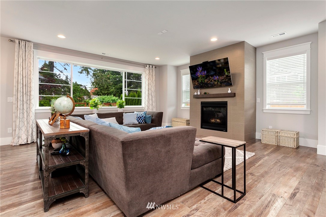 253 Field Place Southeast Renton, WA 98059 - Photo 8 of 40 a living room with furniture a flat screen tv and a fireplace