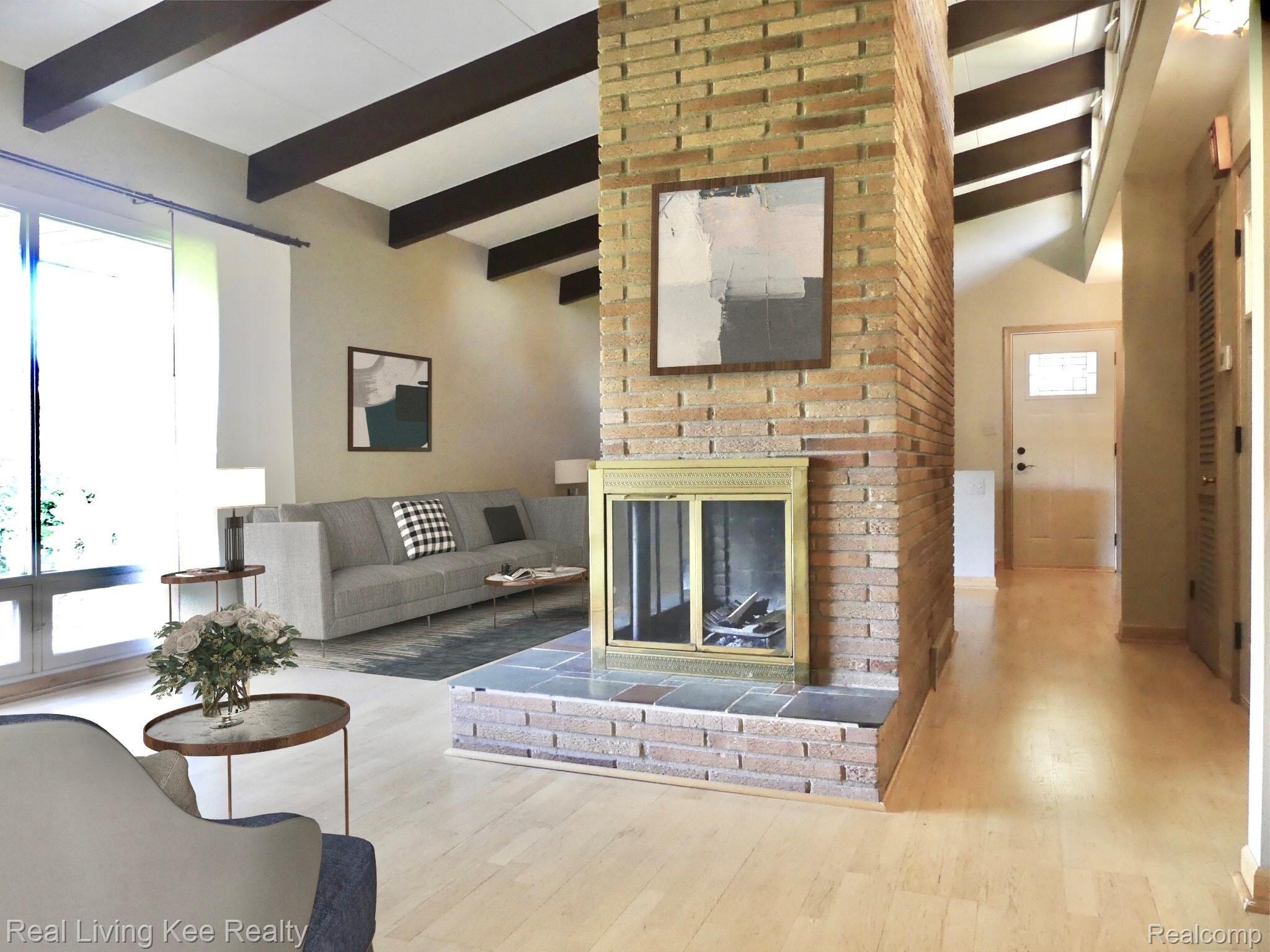 49741 Shelby Road Utica, MI 48317 - Photo 5 of 61 Living room with 2-sided fireplace and beamed vaulted ceiling - virtually staged
