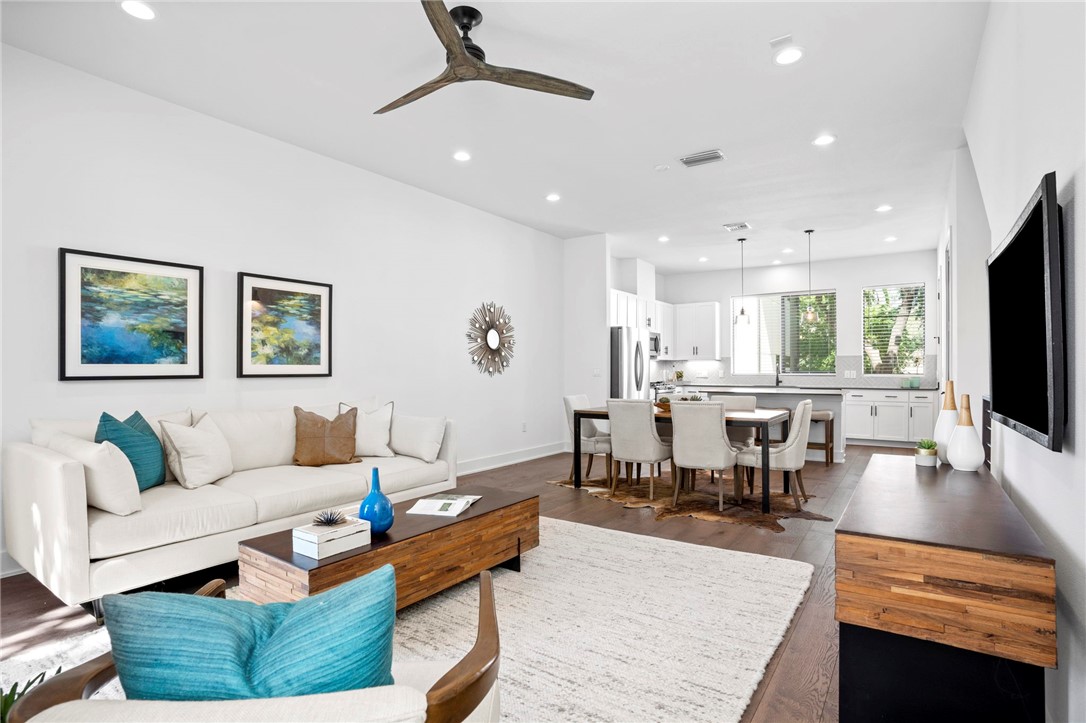 a living room with furniture a flat screen tv and kitchen view