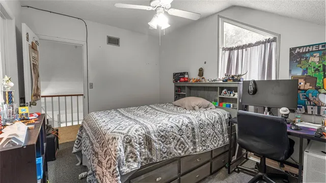 a bed sitting in a bedroom next to a window with pc on the table