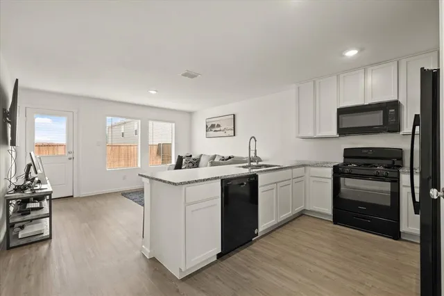a kitchen with granite countertop a stove top oven and cabinets