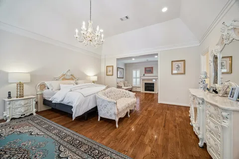 a spacious bedroom with a bed and a chandelier