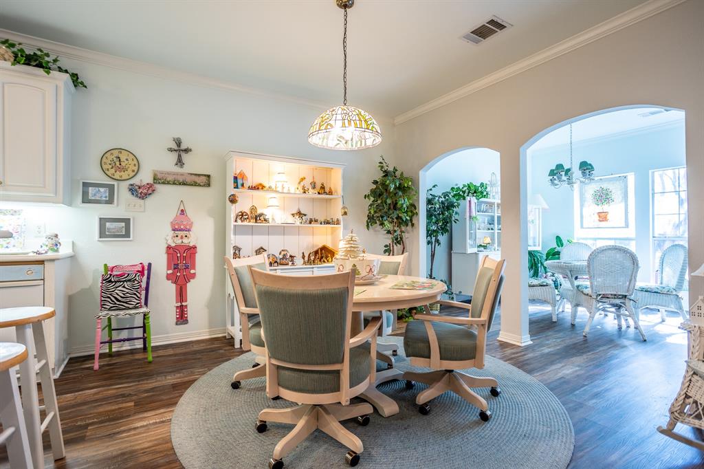 300 East Redbud Lane Lancaster, TX 75146 - Photo 7 of 31 a dining room with wooden floor a chandelier a wooden table and chairs