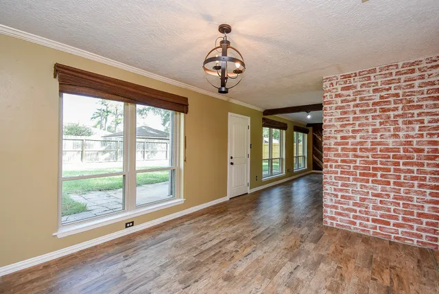 a view of a hallway with wooden floor and a chandelier