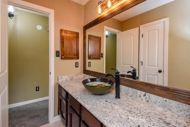 a bathroom with a granite countertop sink and a mirror