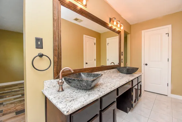 a bathroom with a granite countertop sink and a mirror