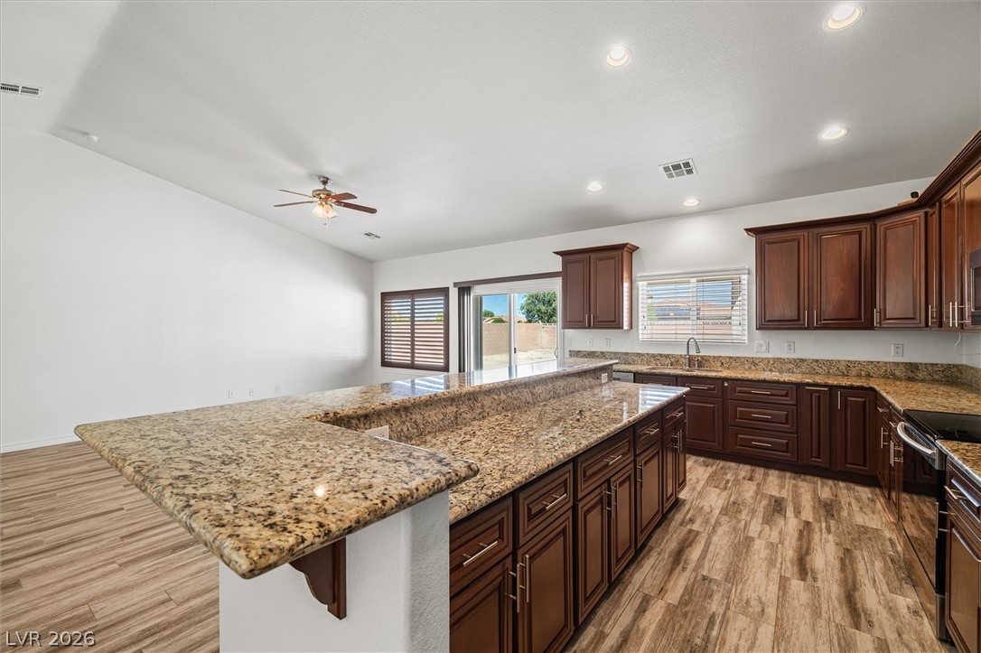 6720 Stubblefield Drive Pahrump, NV 89061 - Photo 17 of 51 A contemporary kitchen features rich cabinetry, granite countertops, and seamless access to outdoor living.