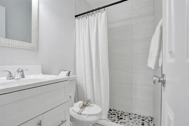 a bathroom with a sink a toilet and shower