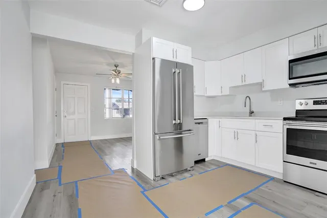 a kitchen with stainless steel appliances a refrigerator stove and sink