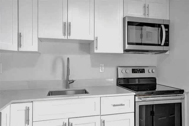 a kitchen with appliances cabinets and a stove top oven