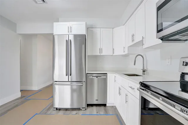 a kitchen with a refrigerator sink and cabinets