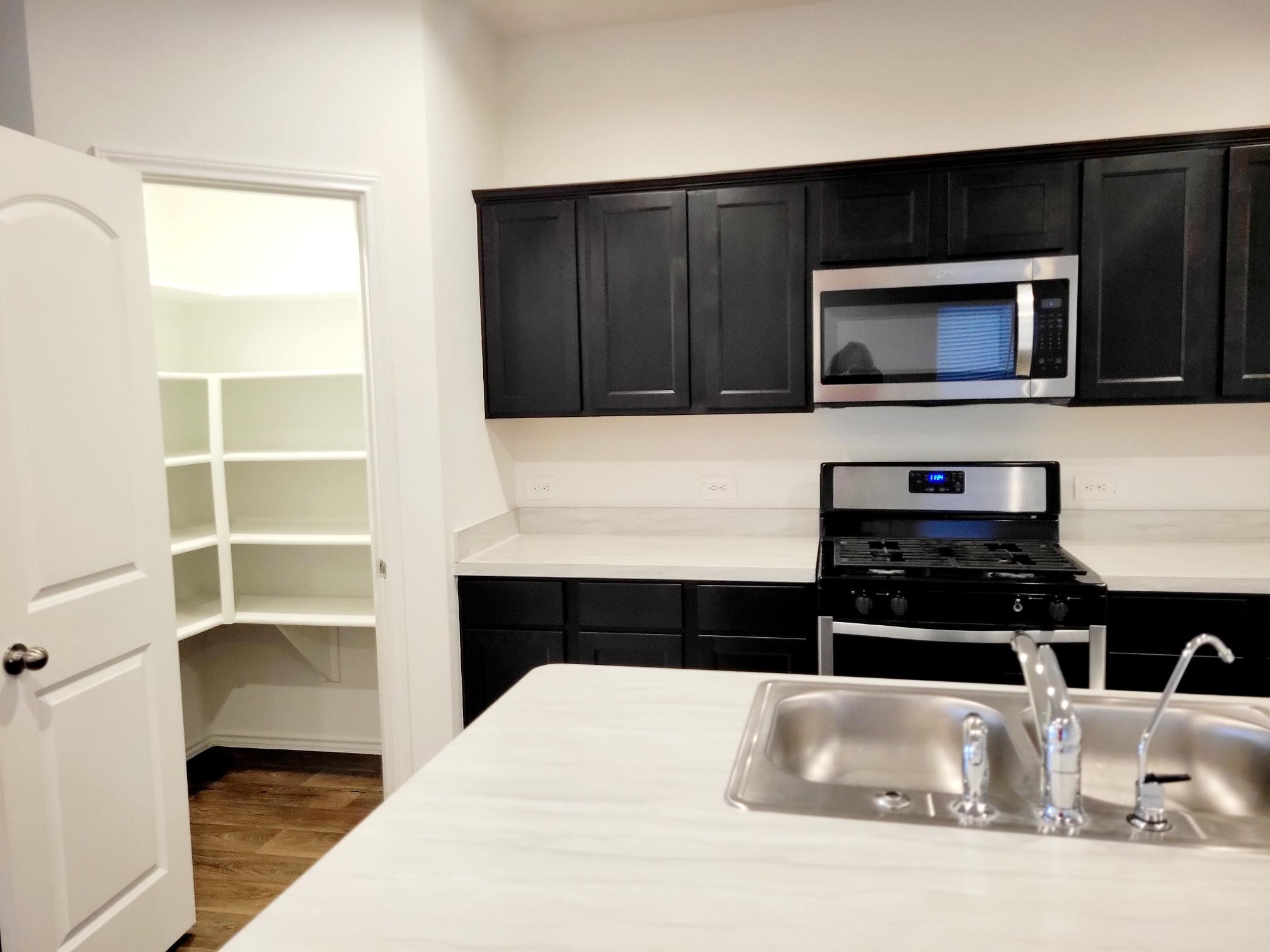 21522 Violet Ridge Road Katy, TX 77449 - Photo 11 of 40 a kitchen with a refrigerator stove and cabinets