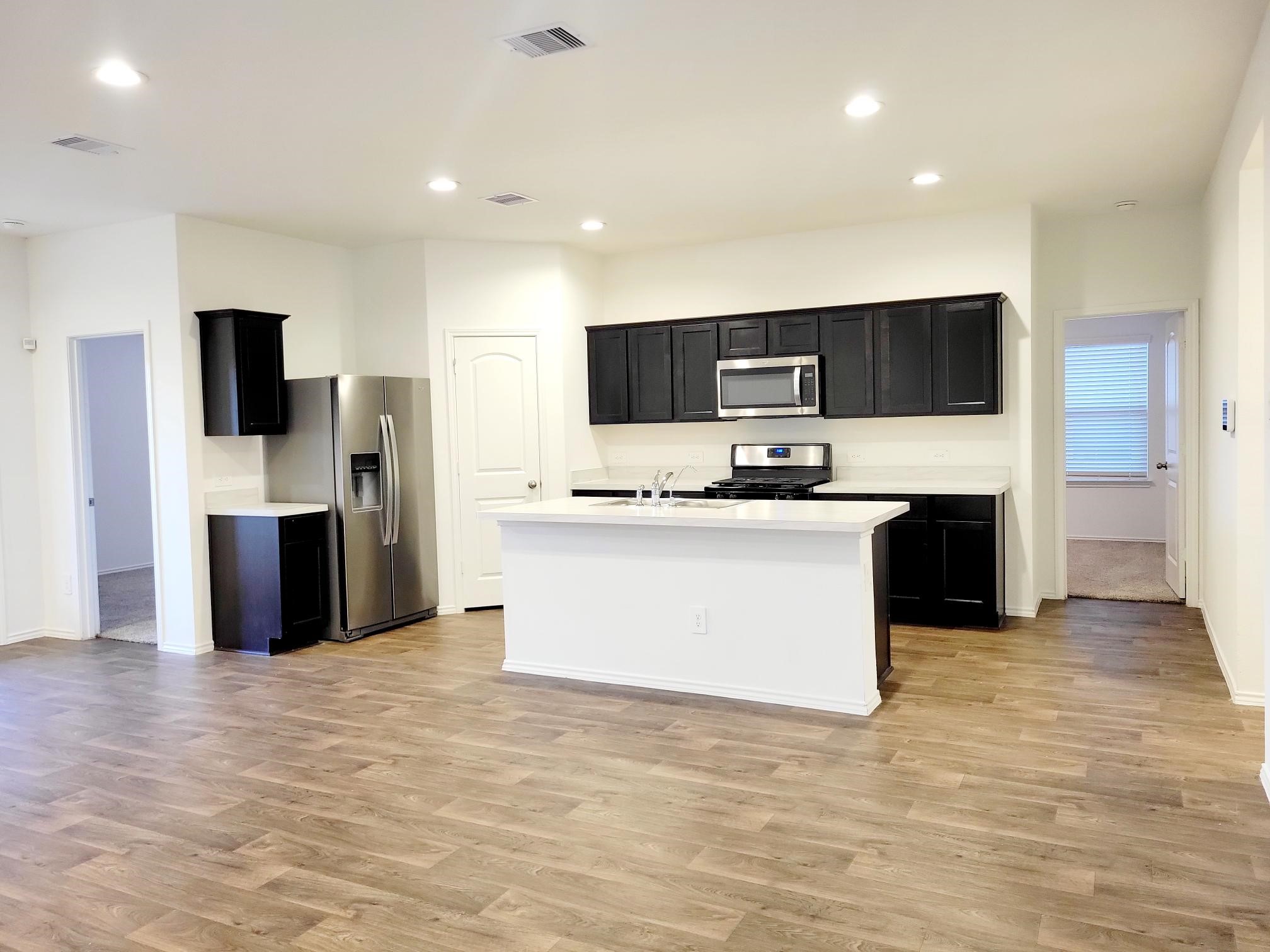 21522 Violet Ridge Road Katy, TX 77449 - Photo 7 of 40 a large kitchen with stainless steel appliances a large counter top a oven a stove and a refrigerator