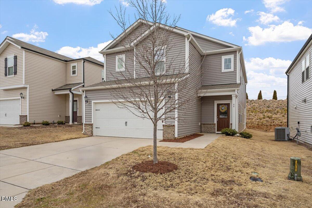 46 Coffee Tree Circle Clayton, NC 27527 - Photo 2 of 36 a front view of a house with a yard and garage