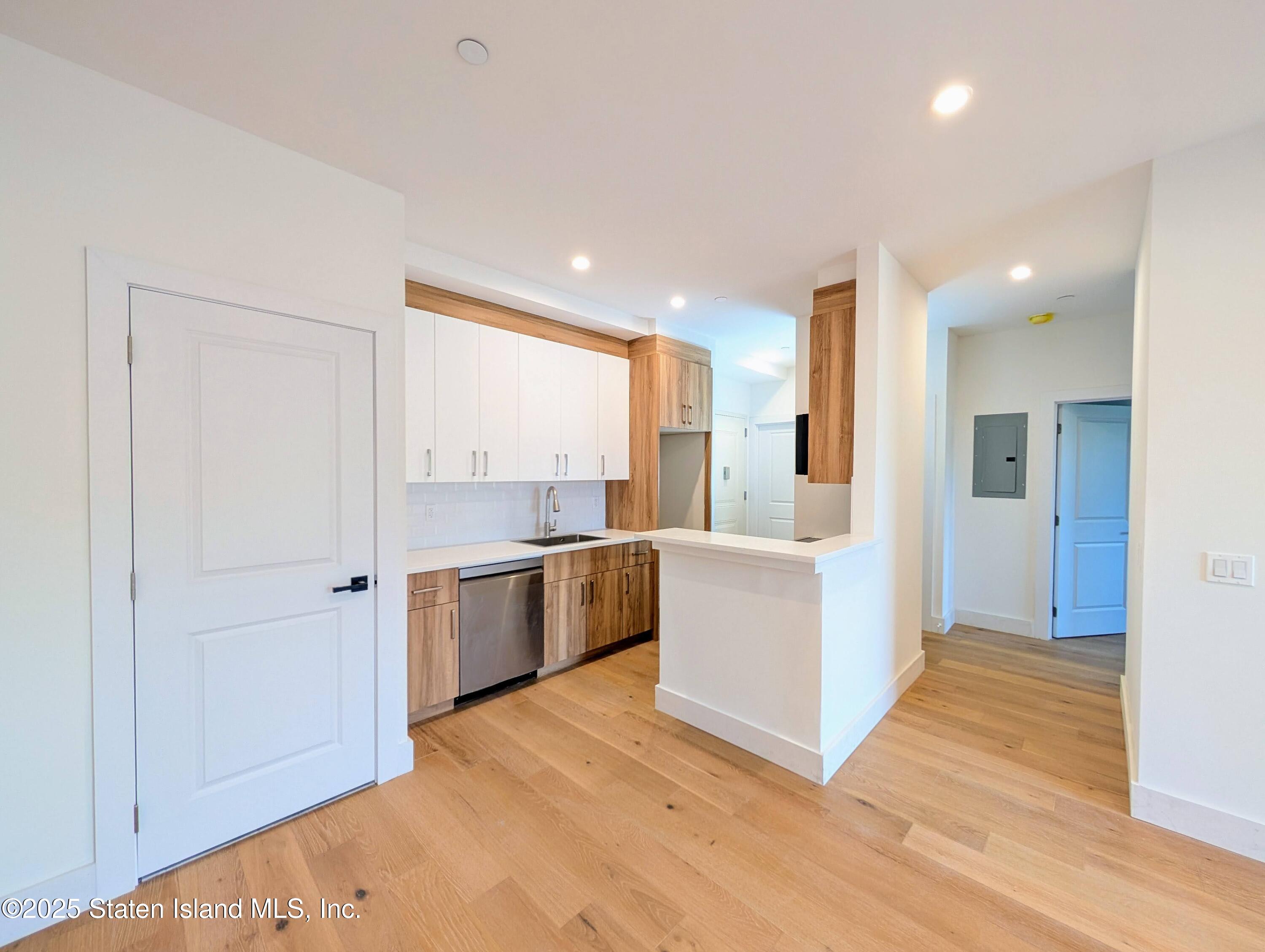 3865 Amboy Road, Unit 4D Staten Island, NY 10308 - Photo 10 of 32 a large white kitchen with a sink and dishwasher a refrigerator with wooden floor