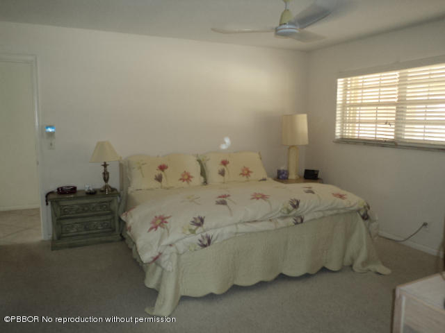 314 Cedar Key Circle Atlantis, FL 33462 - Photo 14 of 23 a bed sitting in a bedroom next to a window