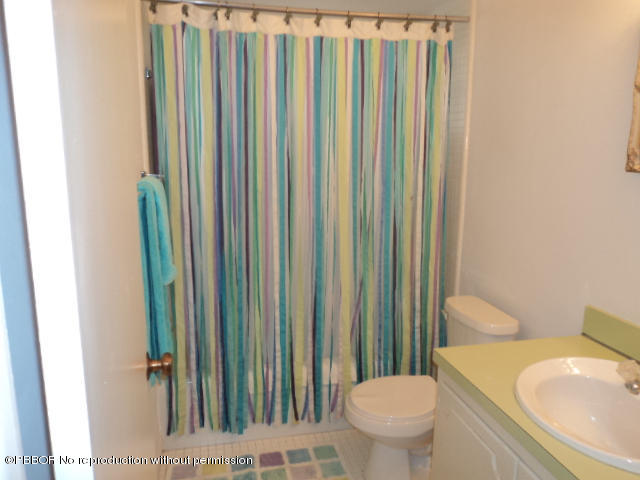 314 Cedar Key Circle Atlantis, FL 33462 - Photo 18 of 23 a bathroom with a toilet a sink and a mirror