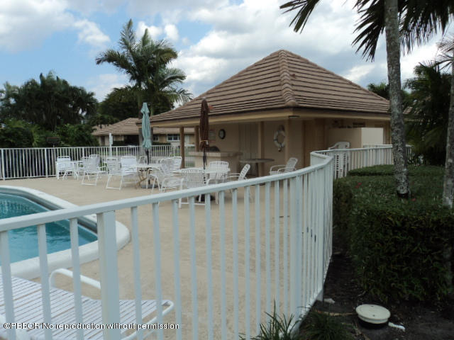 314 Cedar Key Circle Atlantis, FL 33462 - Photo 23 of 23 a roof deck with table and chairs potted plants and palm trees