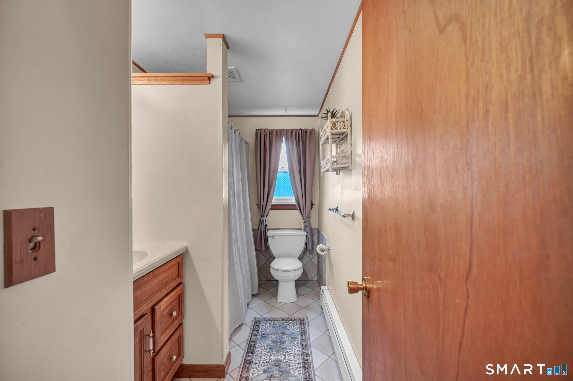 85 Florence Street Newington, CT 06111 - Photo 16 of 26 a bathroom with a toilet and a shower curtain