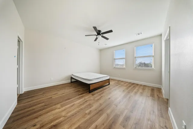 a bedroom with bed and ceiling fan