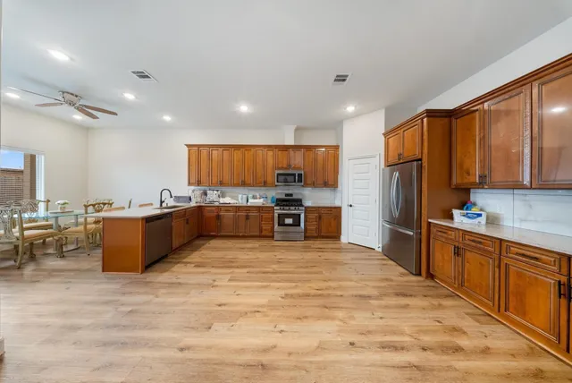 a view of a room with wooden floor ceiling fan and window
