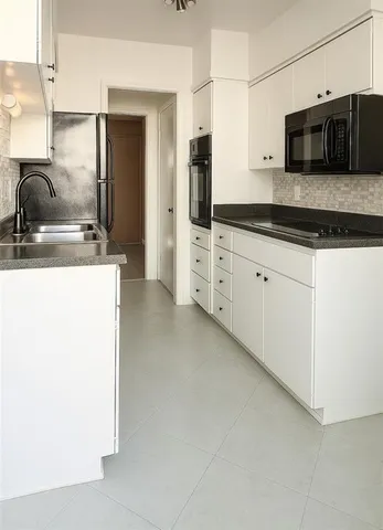 a kitchen with stainless steel appliances granite countertop a sink and a microwave